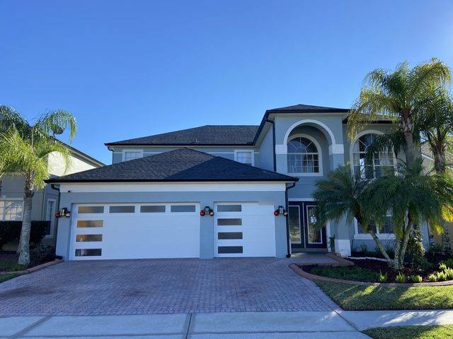 Black seamless gutters and downspouts on a two-story stucco home