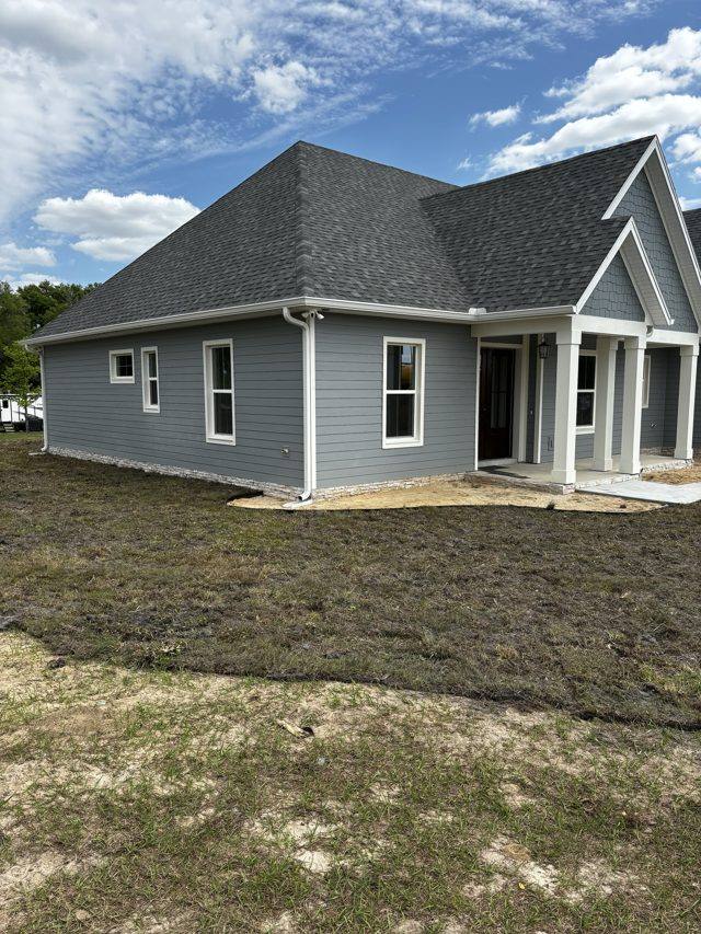 White gutters and downspouts on a new blue-gray home with a covered front porch