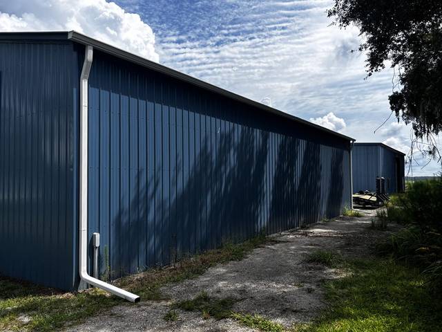 White downspouts on a long blue metal building