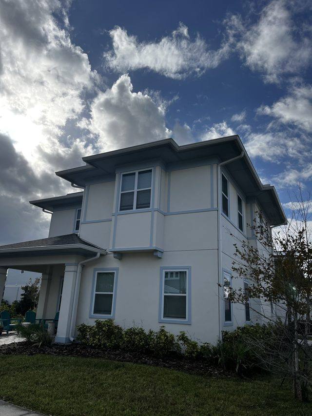 White gutters and downspouts on a two-story home with blue trim