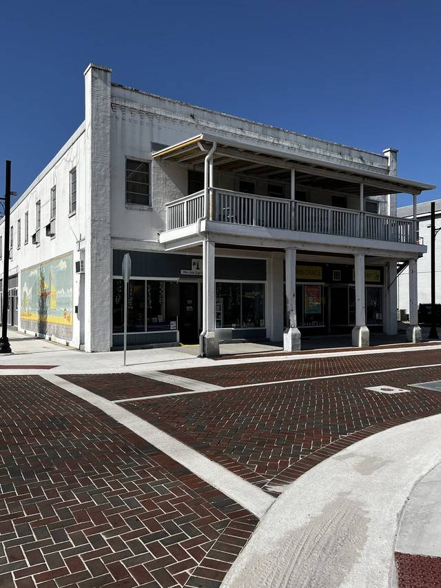 The Conn Building in downtown St. Cloud, with a white downspout running down the corner post under the second-floor balcony
