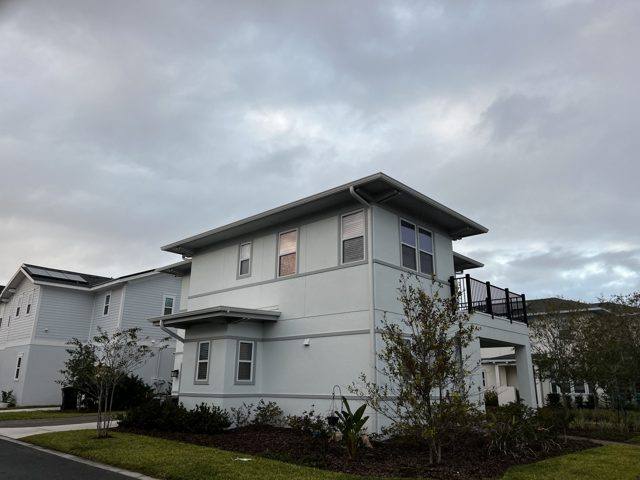 Gray gutters and downspouts on a two-story home with a balcony