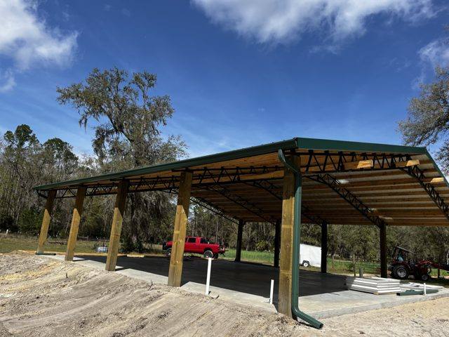 Green gutter and downspout on a new pole barn with a green metal roof