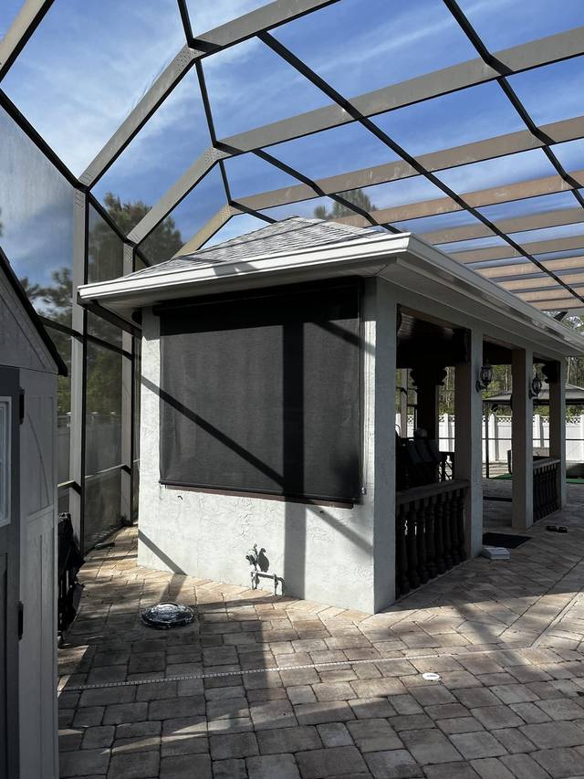 White gutter on a poolside cabana inside a screen enclosure