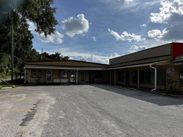 White gutter and downspouts along the covered walkway of a single-story commercial strip