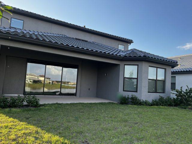 Dark gutter along a tile roof on the back of a modern stucco home