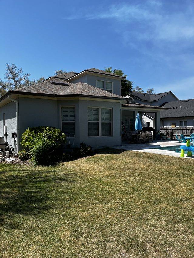 White gutters and downspout on the back of a stucco home