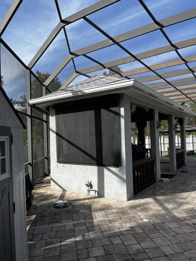 White gutter on a poolside cabana inside a screen enclosure