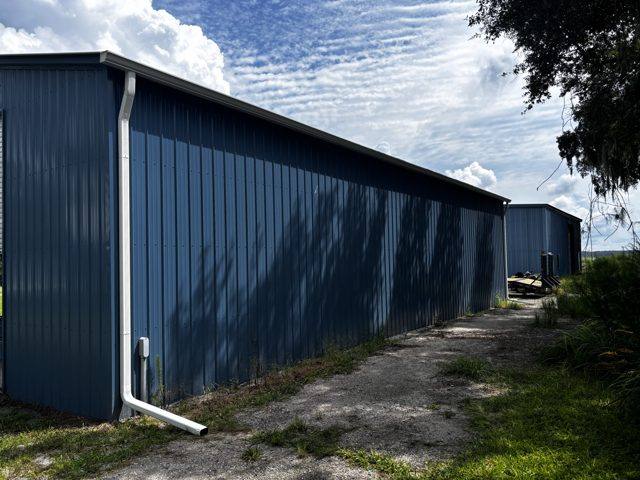 White downspouts on a long blue metal building